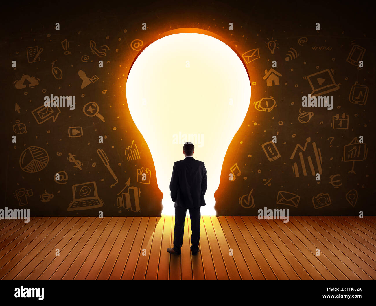 Business man guardando alla luce brillante lampadina nella parete Foto Stock