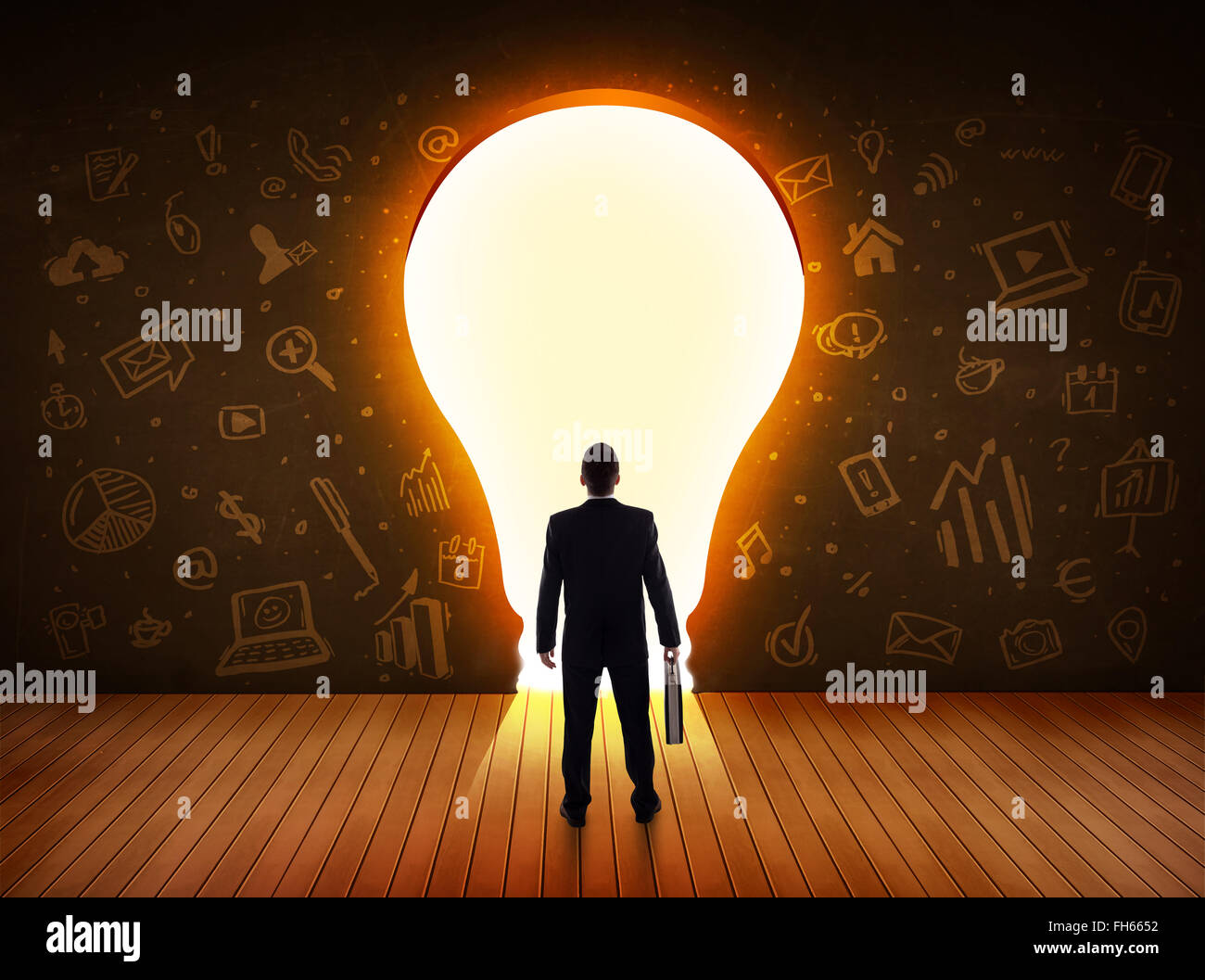 Business man guardando alla luce brillante lampadina nella parete Foto Stock