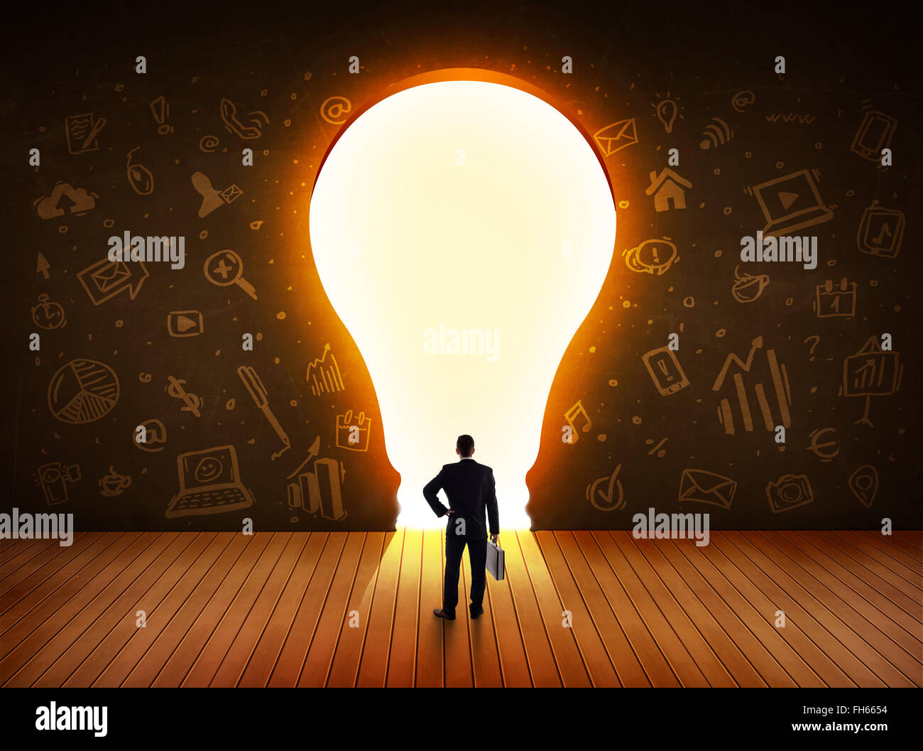 Business man guardando alla luce brillante lampadina nella parete Foto Stock