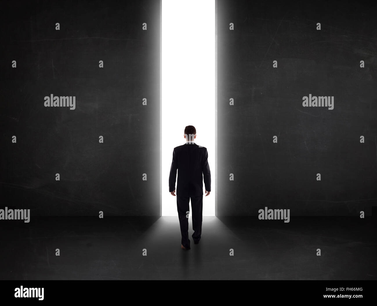 Persona d'affari guardando a parete con la luce di apertura del tunnel Foto Stock