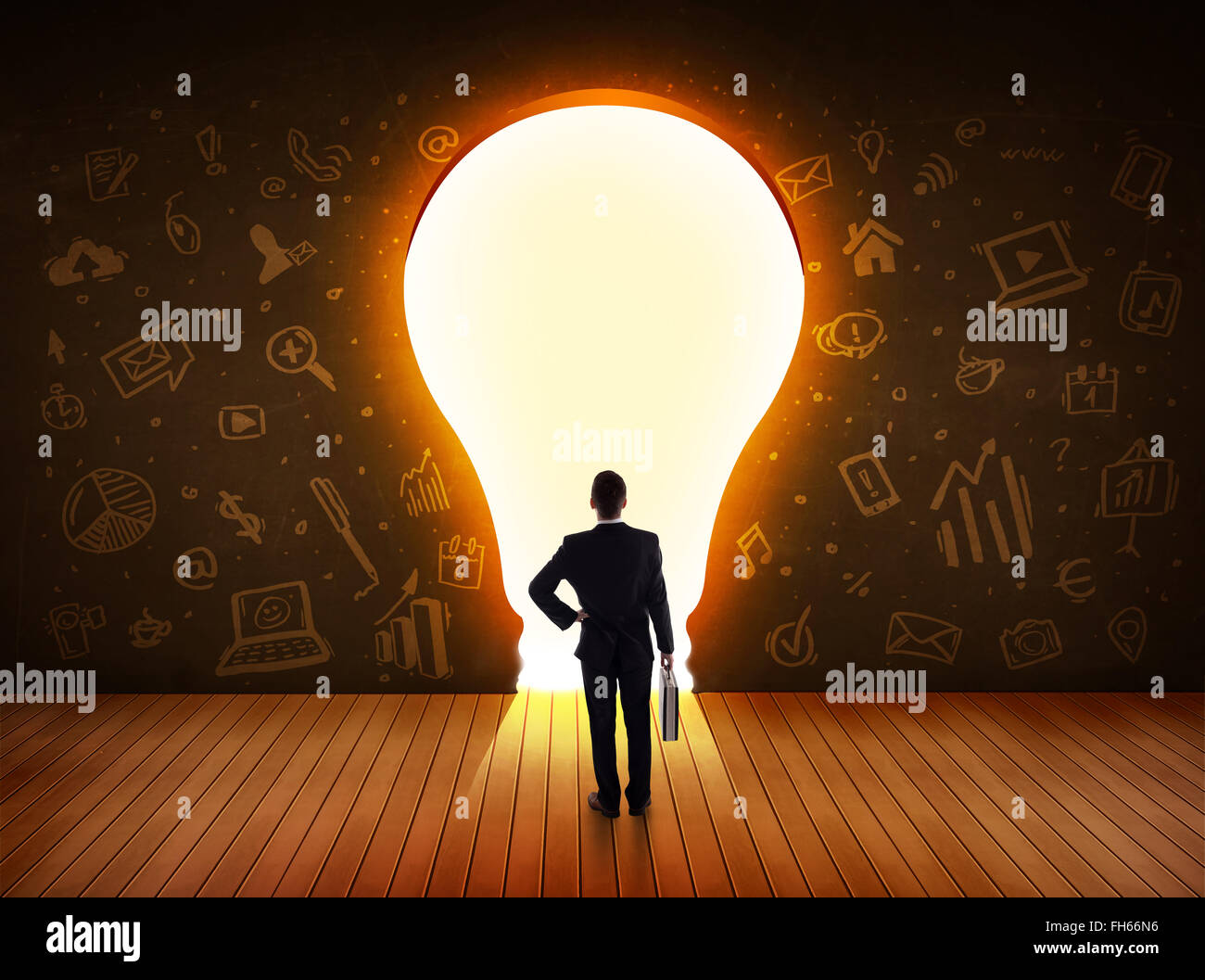 Business man guardando alla luce brillante lampadina nella parete Foto Stock