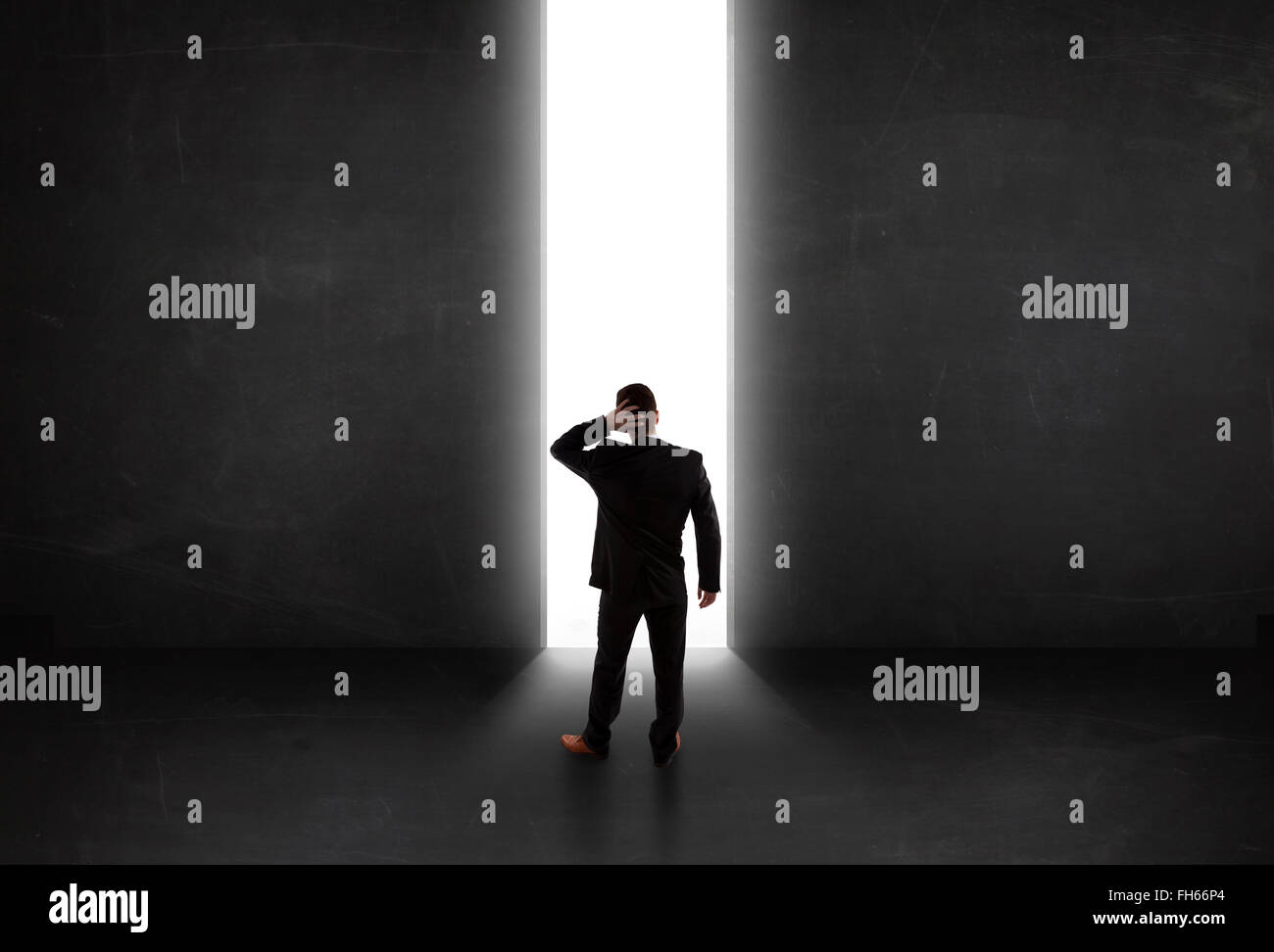 Persona d'affari guardando a parete con la luce di apertura del tunnel Foto Stock