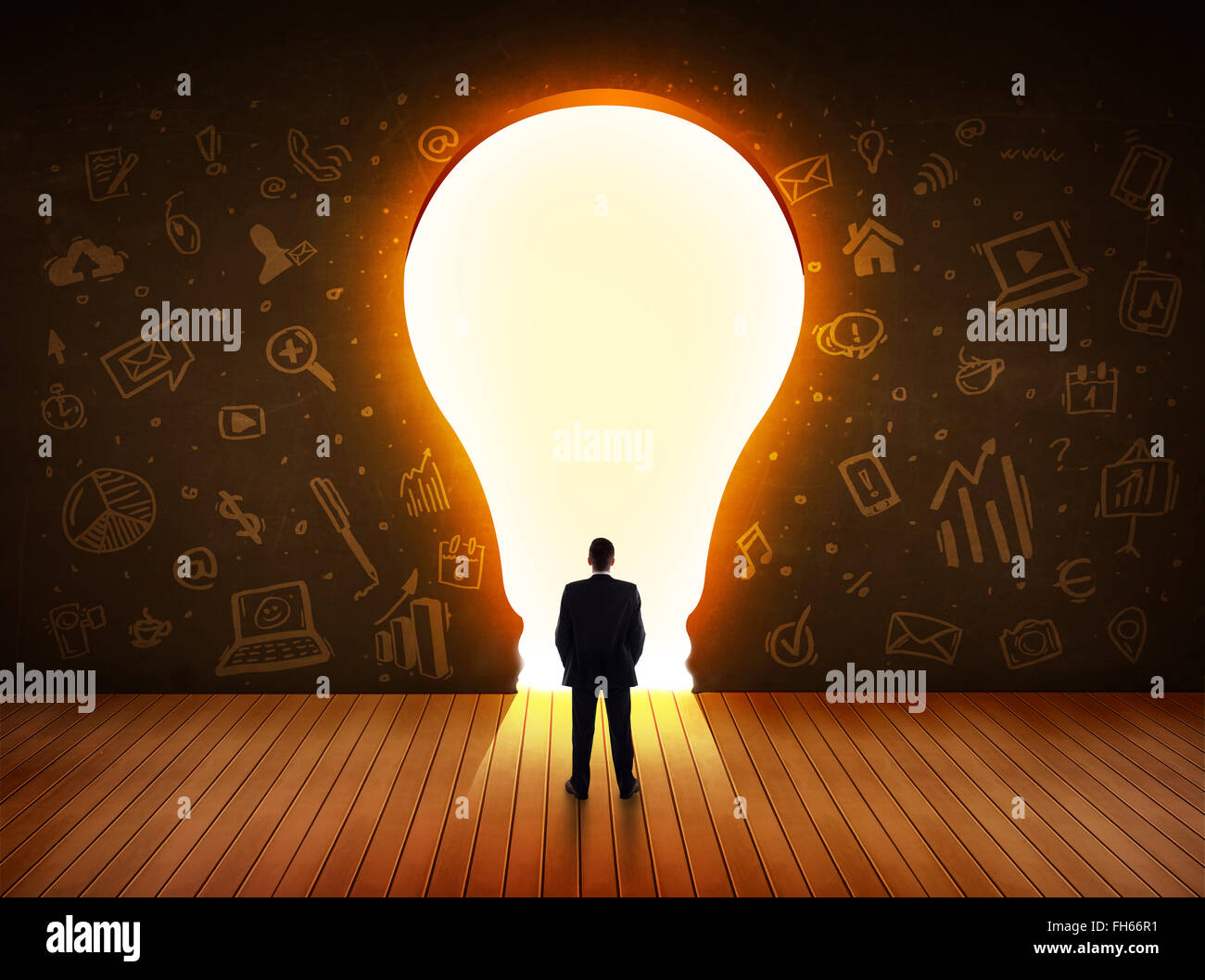 Business man guardando alla luce brillante lampadina nella parete Foto Stock