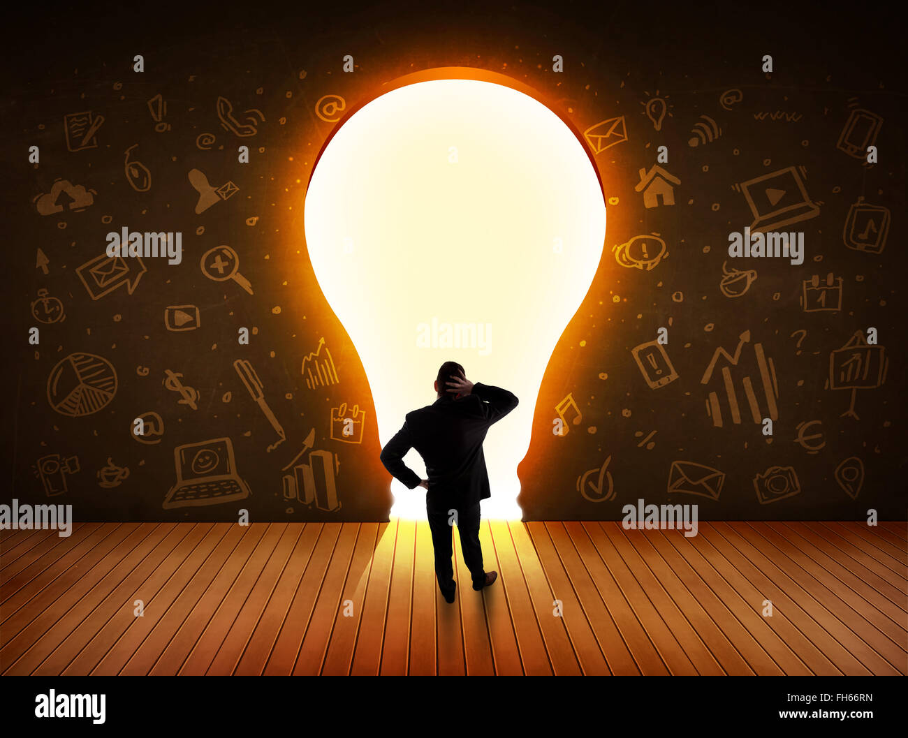 Business man guardando alla luce brillante lampadina nella parete Foto Stock