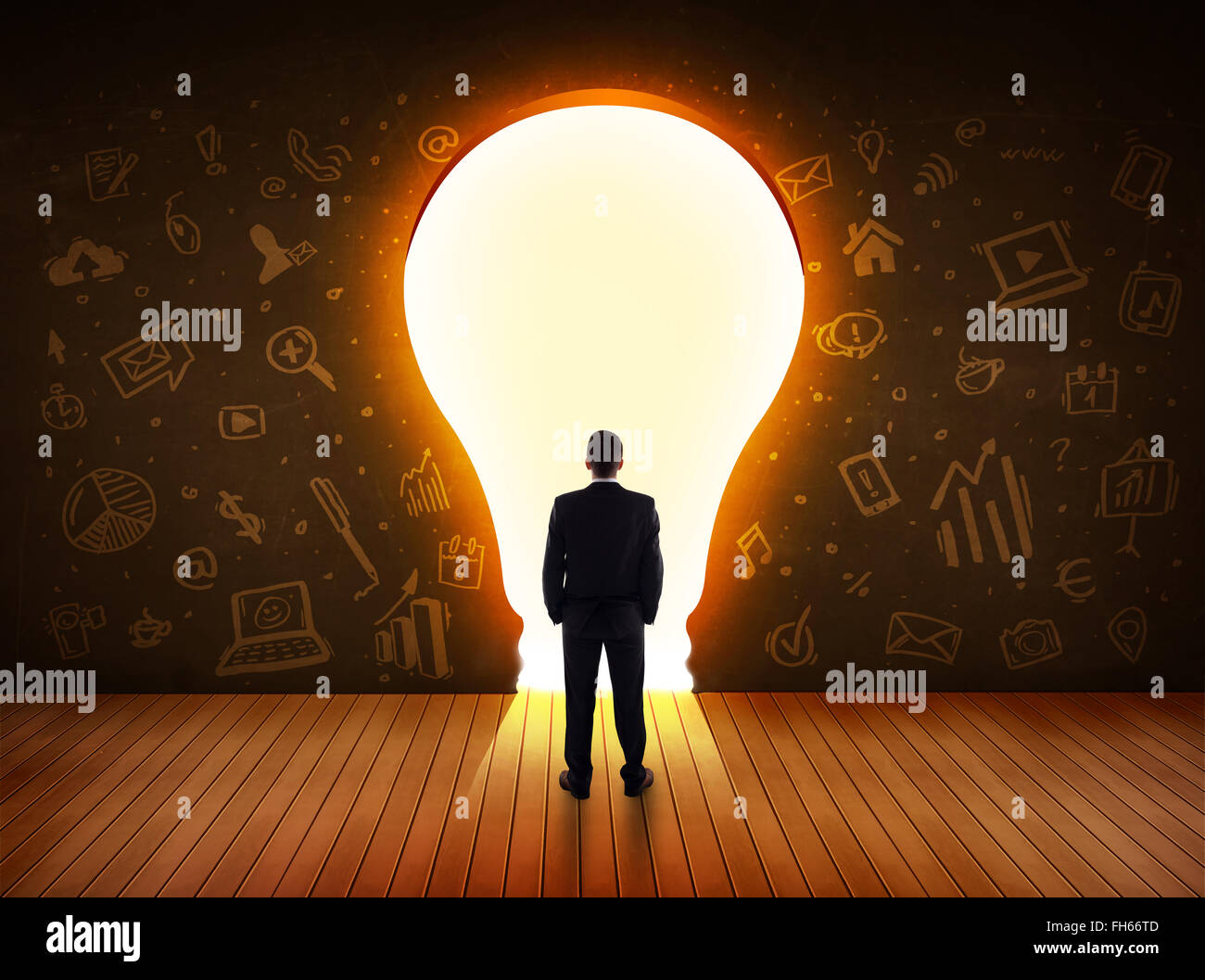 Business man guardando alla luce brillante lampadina nella parete Foto Stock