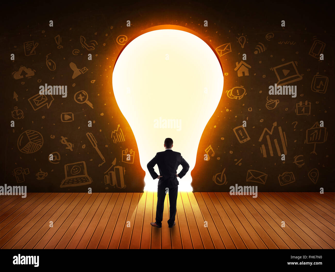 Business man guardando alla luce brillante lampadina nella parete Foto Stock