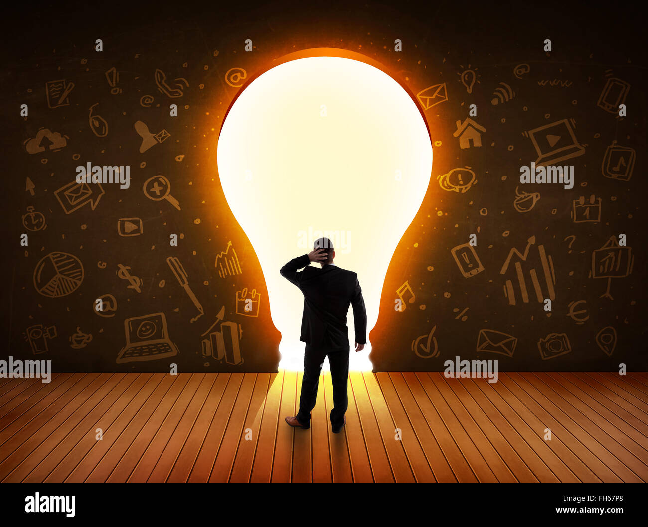 Business man guardando alla luce brillante lampadina nella parete Foto Stock