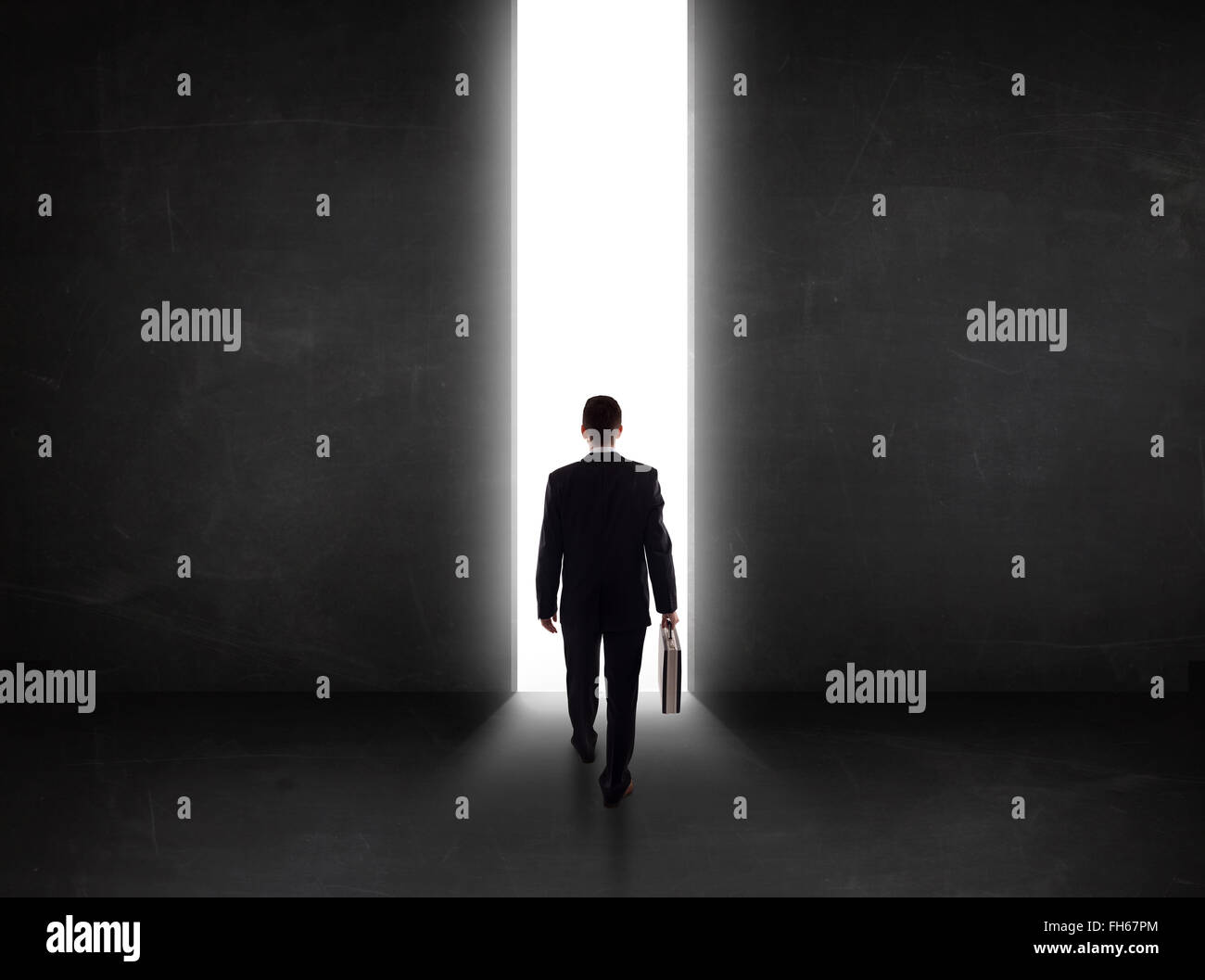 Persona d'affari guardando a parete con la luce di apertura del tunnel Foto Stock