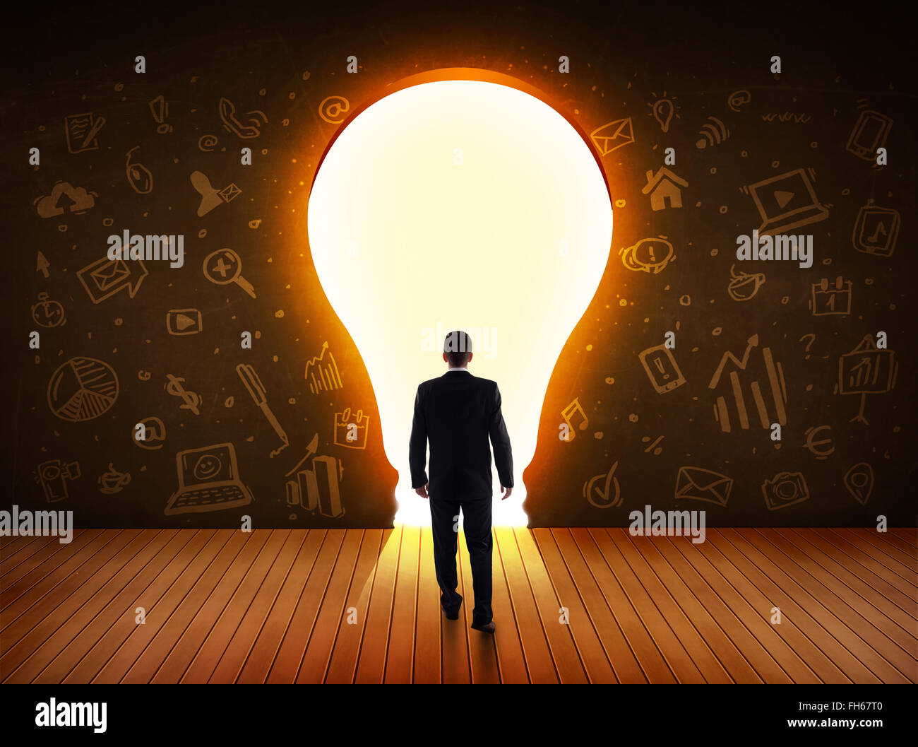 Business man guardando alla luce brillante lampadina nella parete Foto Stock