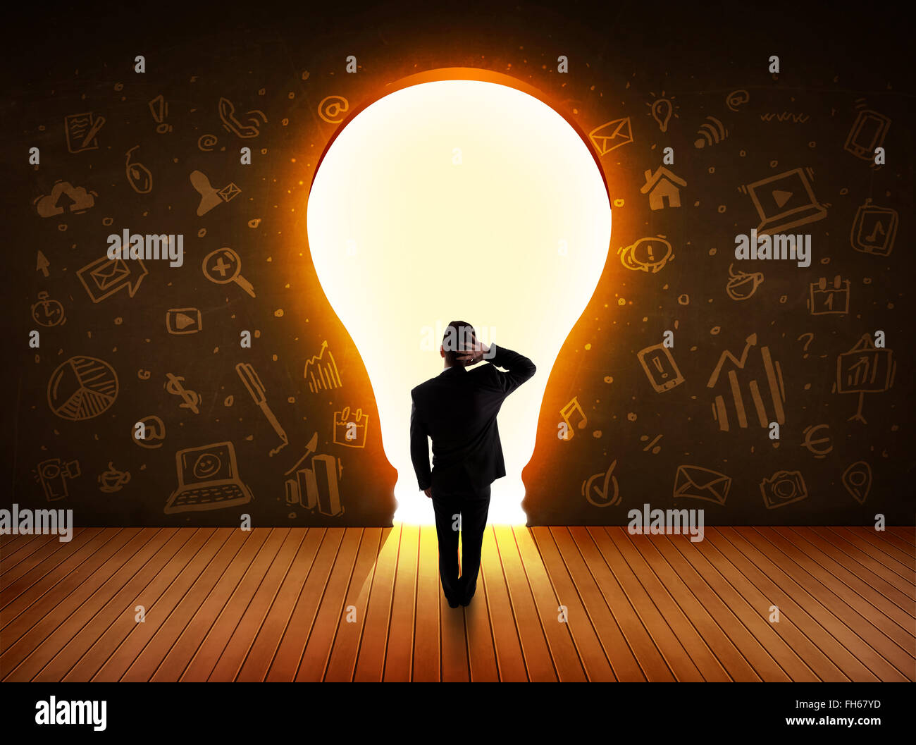 Business man guardando alla luce brillante lampadina nella parete Foto Stock