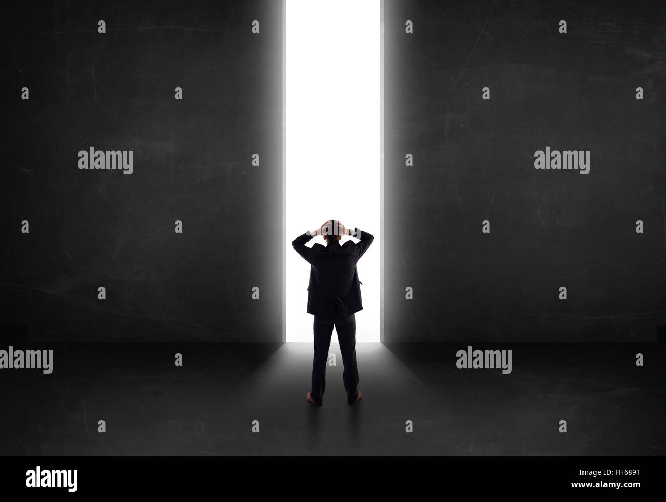 Persona d'affari guardando a parete con la luce di apertura del tunnel Foto Stock