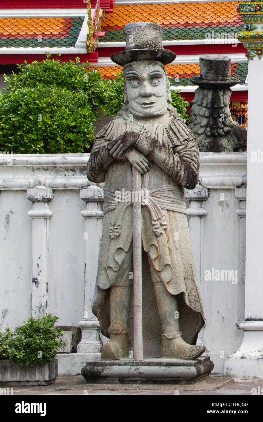 Farang guard statue con top hat e grande naso è una caricatura di occidentali al Wat Pho Bangkok, Thailandia Foto Stock