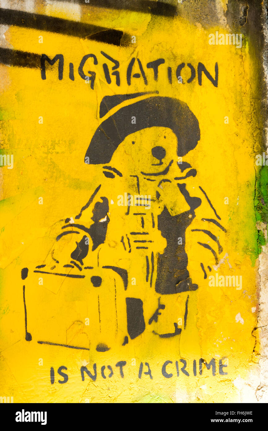 Graffiti politici in Exarcheia, Atene, dotate di Paddington orso con una valigia e la frase "mobilità non è un crimine". Foto Stock