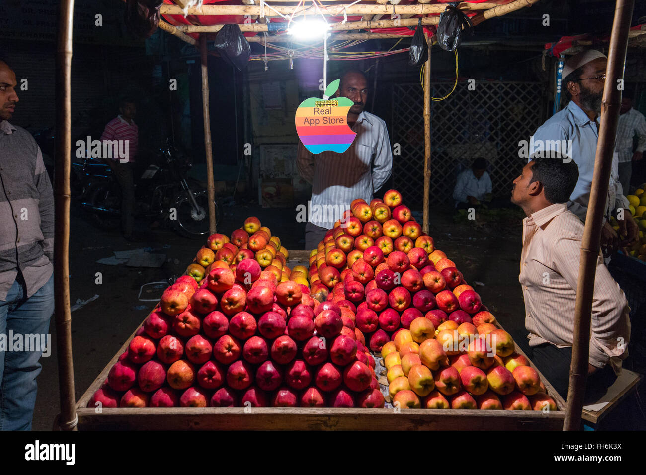 Un fornitore di frutta vende le mele con logo Apple sospesi dal carrello in Hyderabad, India Foto Stock