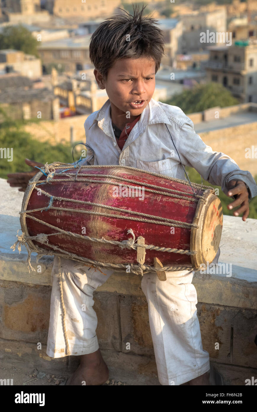Ragazzo in India la riproduzione di un tamburo tradizionale Foto Stock