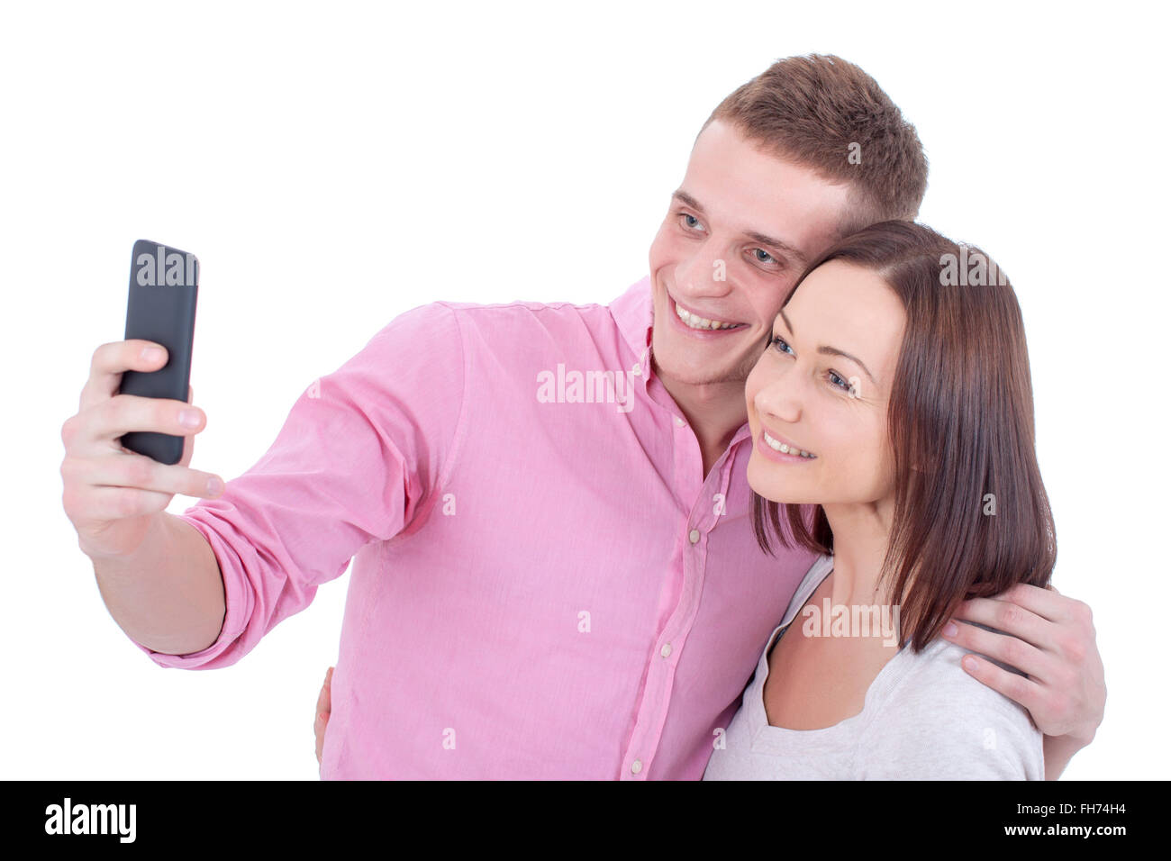 Una giovane bella e felice coppia prendendo un selfie con uno smartphone. Foto Stock