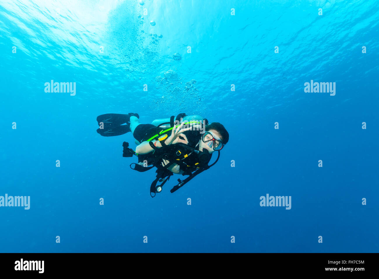 Femmina scuba diver underwater mostra segnale di ok Foto Stock