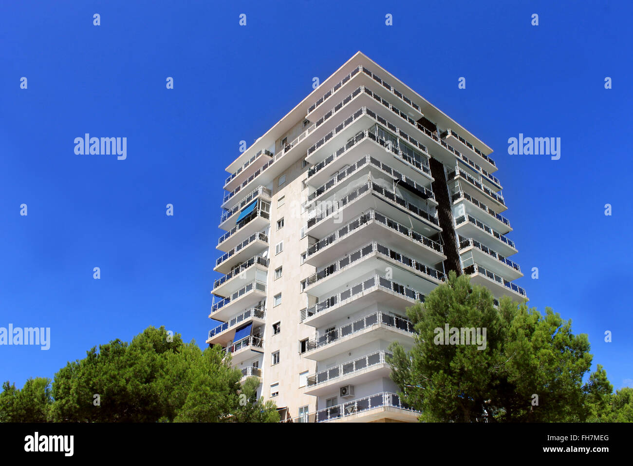 Esterno di un alto e moderno edificio di appartamenti con cielo blu sullo sfondo. Foto Stock