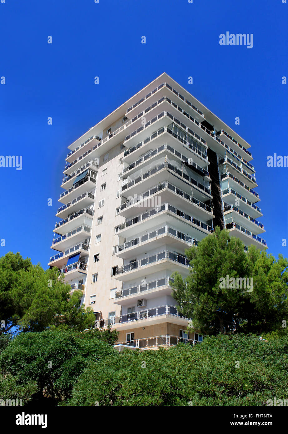 Esterno di un alto e moderno edificio di appartamenti con cielo blu sullo sfondo. Foto Stock