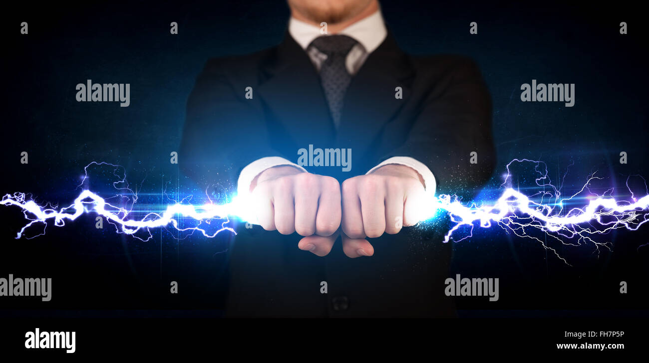 Business man holding elettricità vite di luce nelle sue mani Foto Stock
