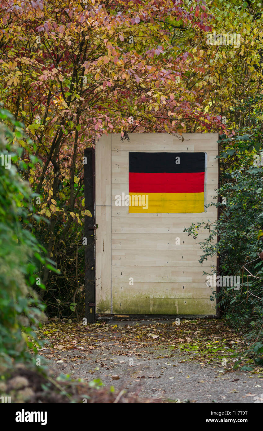 Il percorso che conduce verso un giardino porta con bandiera tedesca Foto Stock