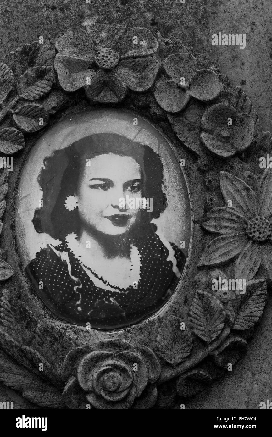 Bassorilievo in pietra medaglione floreale che racchiude la fotografia di una donna Foto Stock