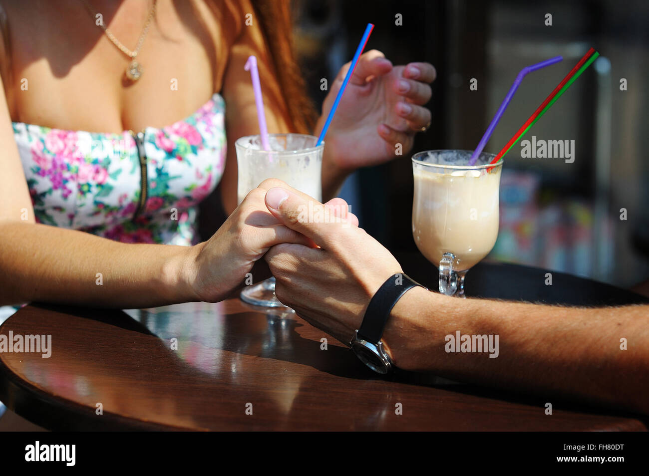 Giovane amore bere il caffè nella caffetteria, tenendo reciprocamente la mano Foto Stock