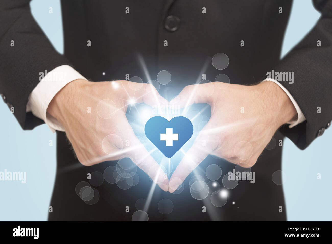 Le mani la creazione di un form con cuore blue cross Foto Stock