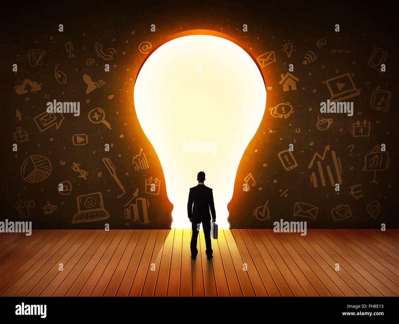 Business man guardando alla luce brillante lampadina nella parete Foto Stock