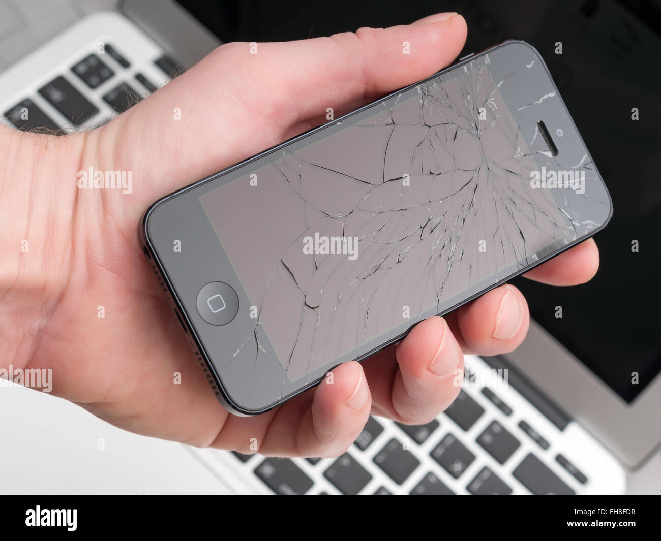 Los Angeles, CA, Stati Uniti d'America - 07 dicembre 2015: l'uomo tiene in mano rotto Apple iPhone con schermo rotto Foto Stock