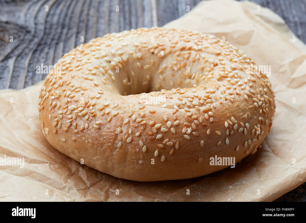 Il SESAMO bagel in sacchetto di carta sul tavolo in legno Foto Stock