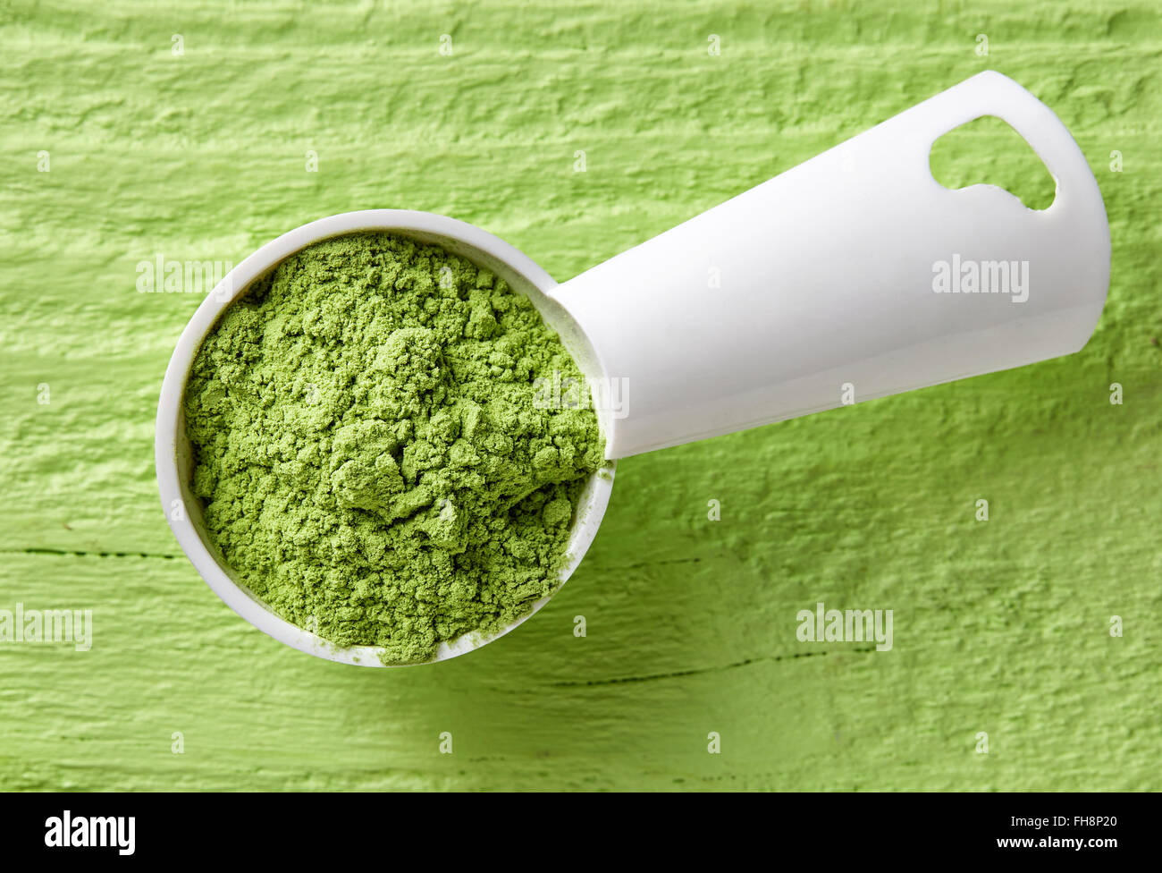 Misurino di orzo o di erba di frumento polvere sul tavolo verde, vista dall'alto Foto Stock