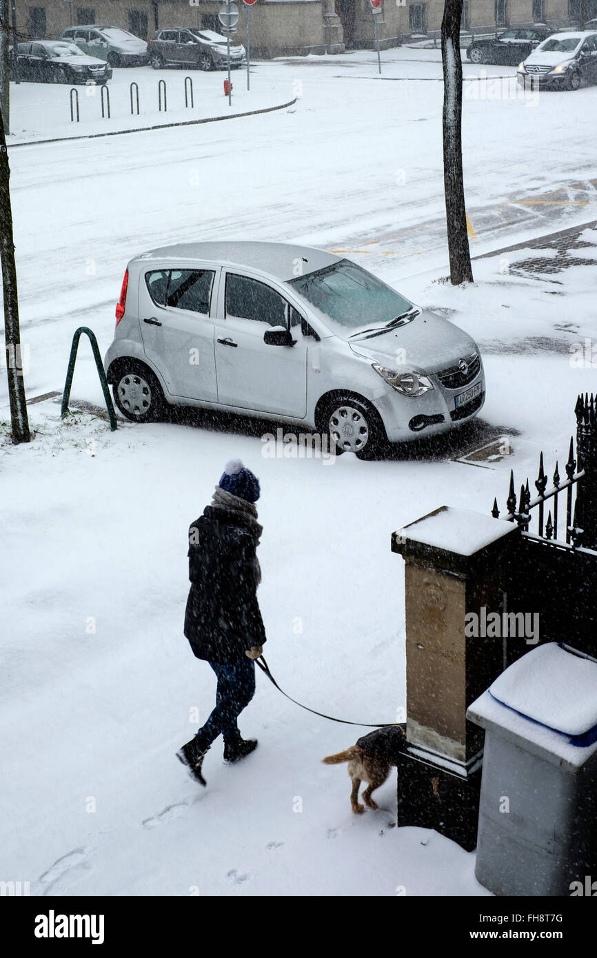 Macchina parcheggiata su un marciapiede, Donna che cammina il suo cane, neve in città, Strasburgo, Alsazia, Francia, Europa Foto Stock