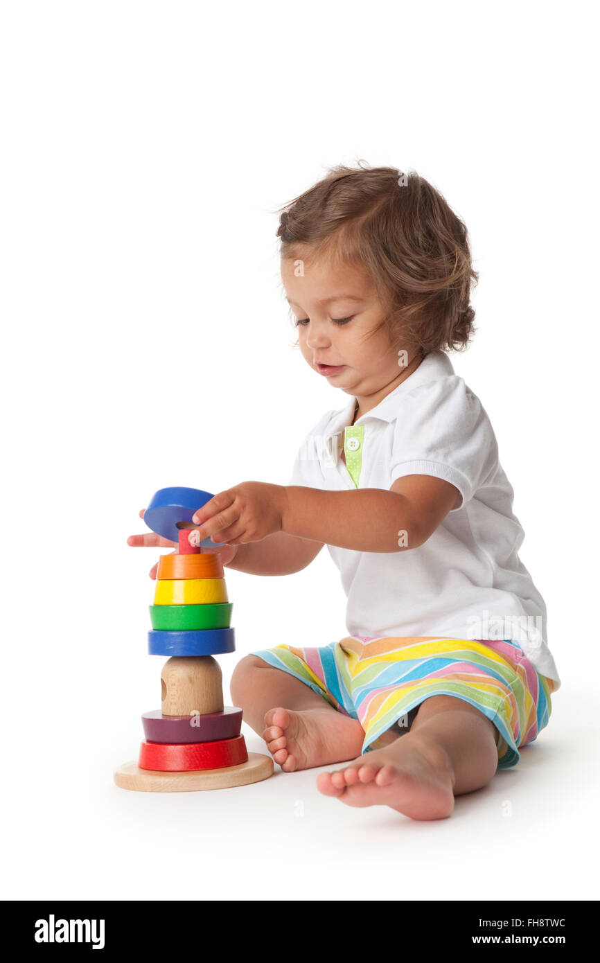 Il Toddler ragazza che gioca con i mattoni colorati su sfondo bianco Foto Stock