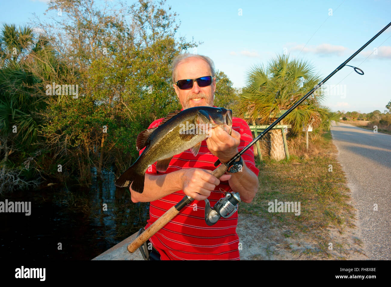 Un pescatore in Florida, Stati Uniti d'America tenendo un largemouth bass ha catturato Foto Stock