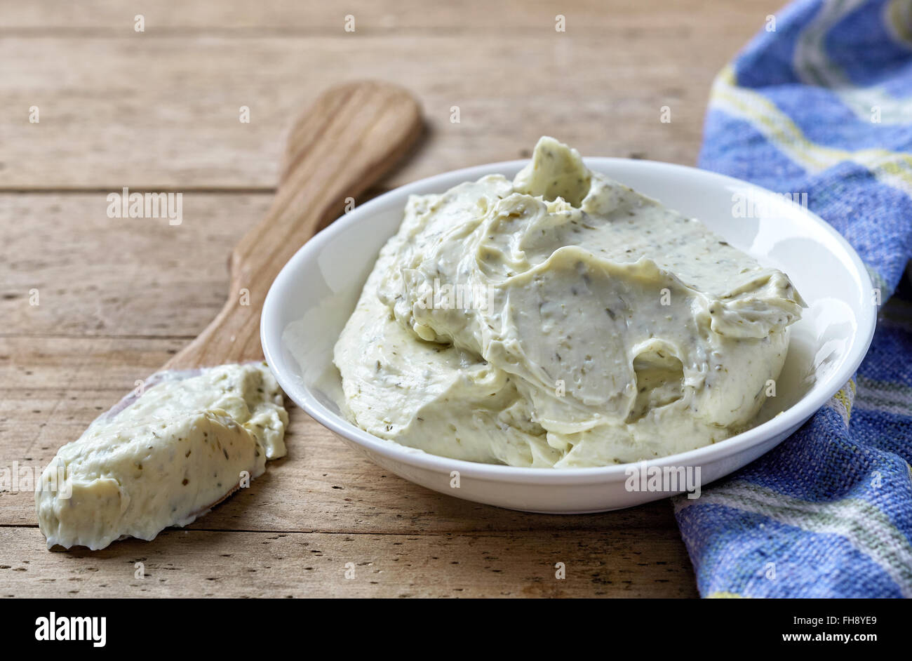 Ciotola di crema di formaggio con erbe sul tavolo di legno Foto Stock