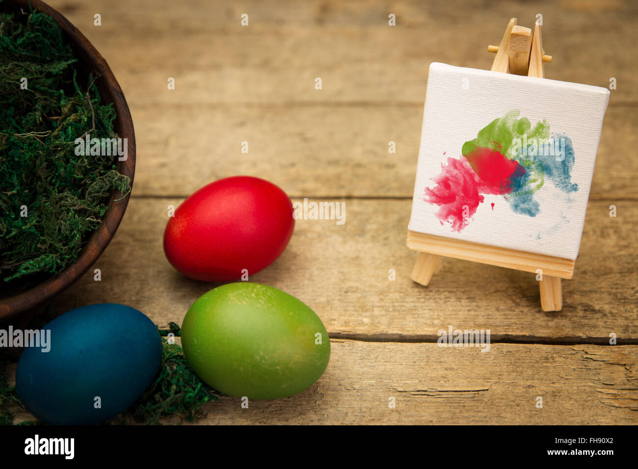 Tre uova colorate su uno sfondo di legno, canvas vuoto con i BLOB Foto Stock