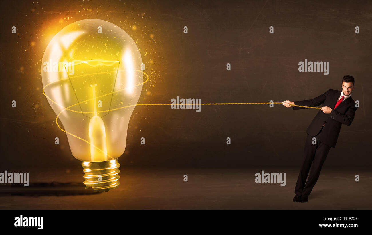 Business man tirando una grande e luminosa incandescente lampadina della luce Foto Stock