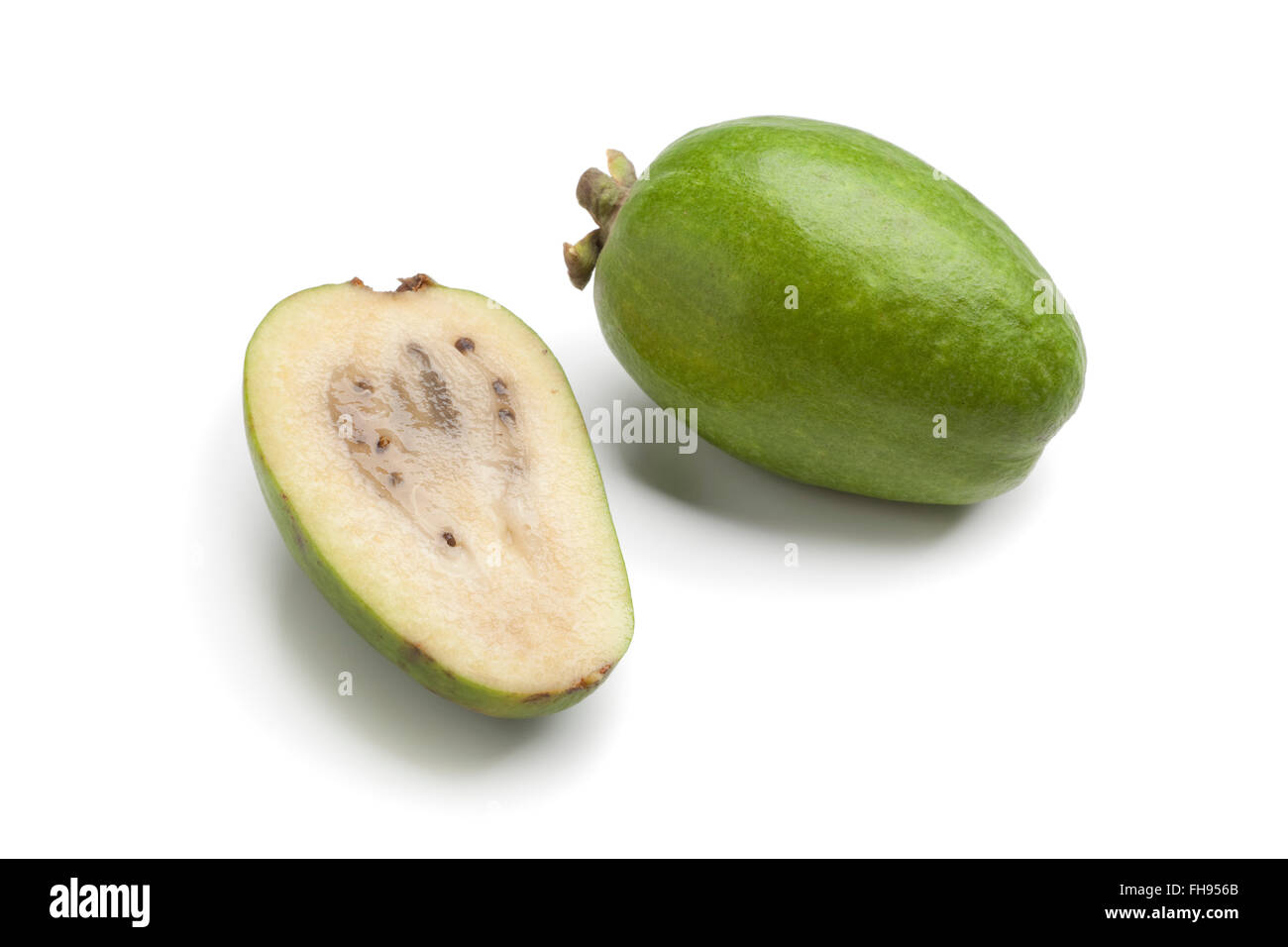 Intero e metà Feijoa fresco frutta su sfondo bianco Foto Stock