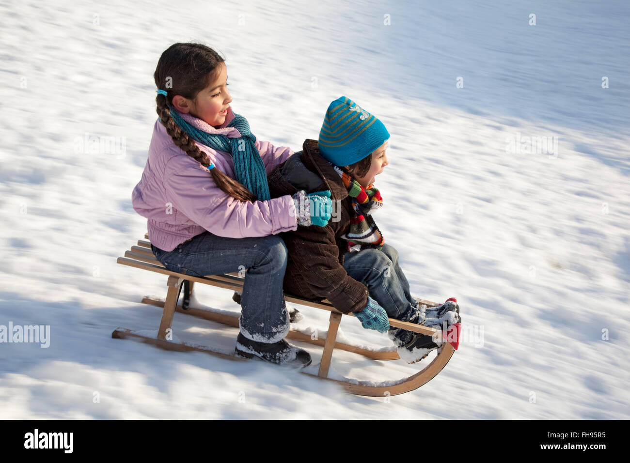 Due bambini su una slitta avente il divertimento sulla neve Foto Stock