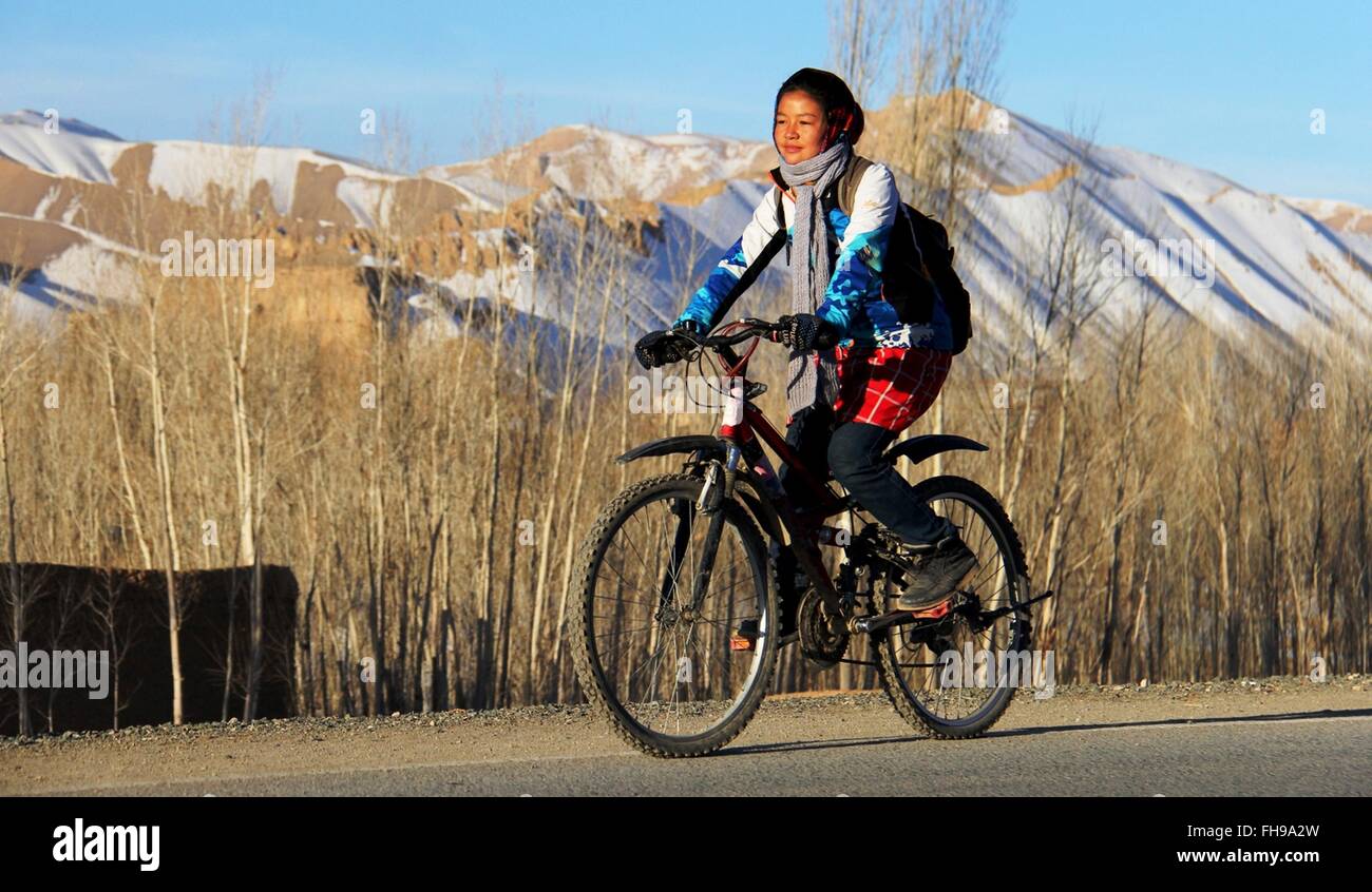 Bamyan, Afghanistan. Il 23 febbraio, 2016. Una donna afghana rides bicicletta durante una manifestazione ciclistica nella provincia di Mazar-i-Sharif, Afghanistan, Feb 23, 2016. Non vi è nessuna restrizione per le donne per andare in bicicletta ma è comunque raro vedere femmina piloti di bicicletta in Afghanistan. © Latif Azimi ha/Xinhua/Alamy Live News Foto Stock