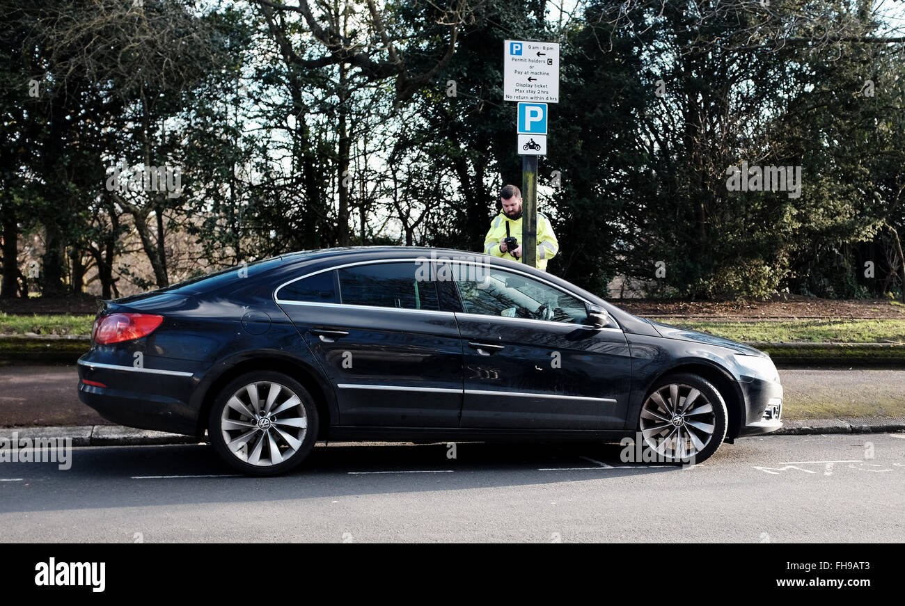 Un responsabile del traffico emette un multo per un parcheggio per un'auto a Queens Park Brighton Sussex Regno Unito 2016 Foto Stock