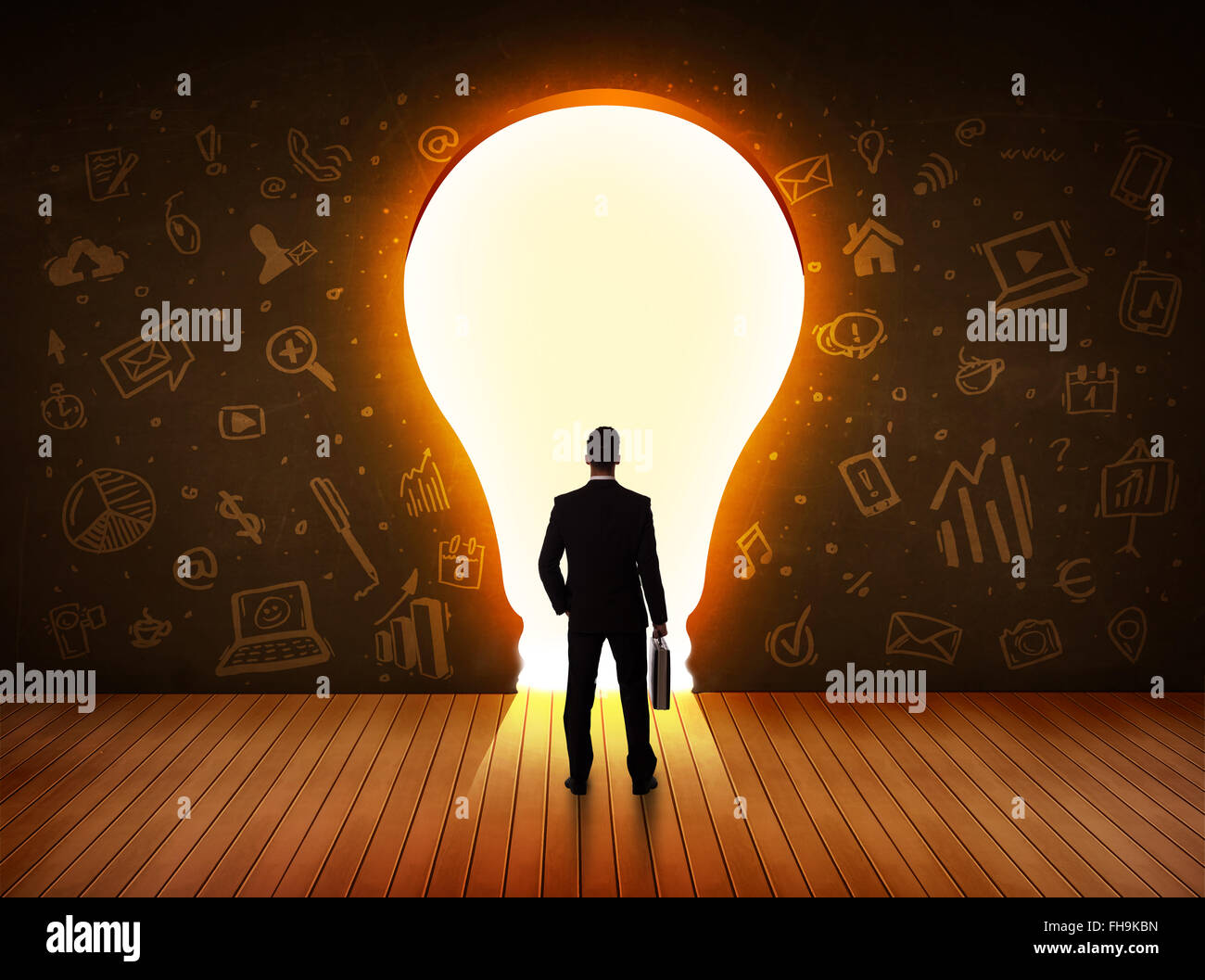 Business man guardando alla luce brillante lampadina nella parete Foto Stock