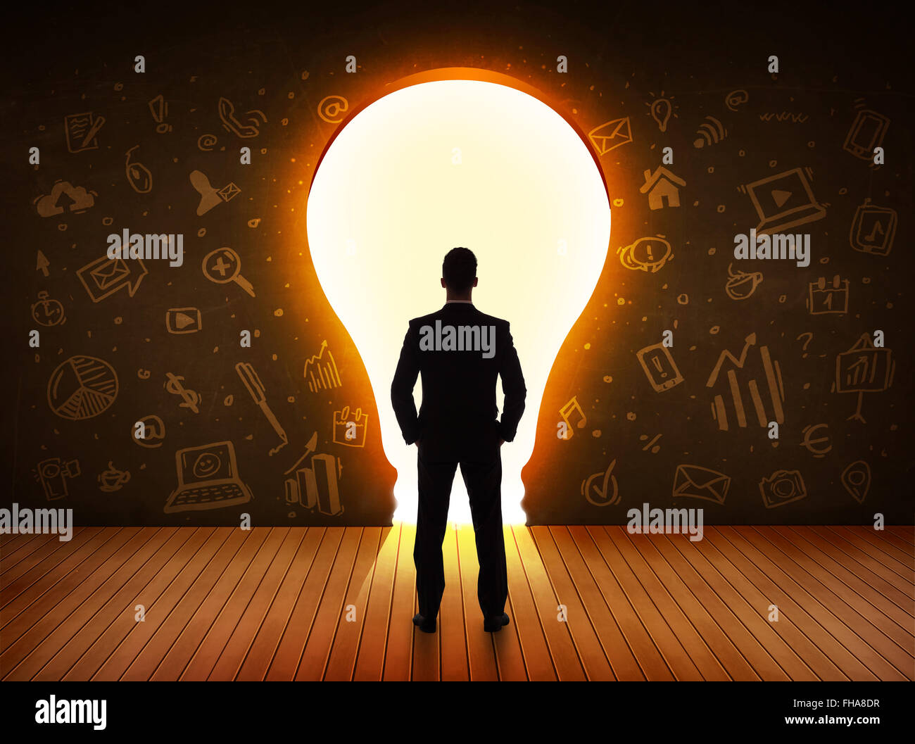 Business man guardando alla luce brillante lampadina nella parete Foto Stock