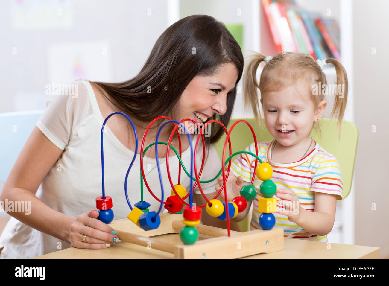 Capretto felice ragazza e mom riproduzione giocattolo di sviluppo Foto Stock