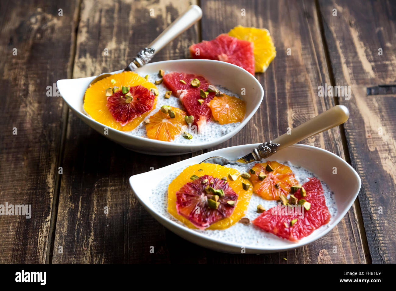 Chia Pudding e fette di arancia arancio sanguigno e pompelmo, bocce su legno Foto Stock