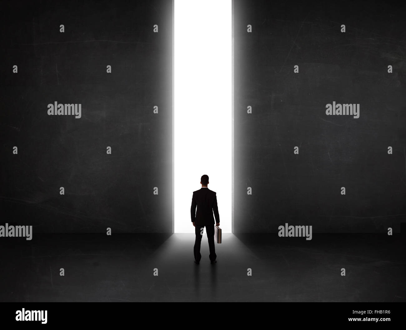 Persona d'affari guardando a parete con la luce di apertura del tunnel Foto Stock