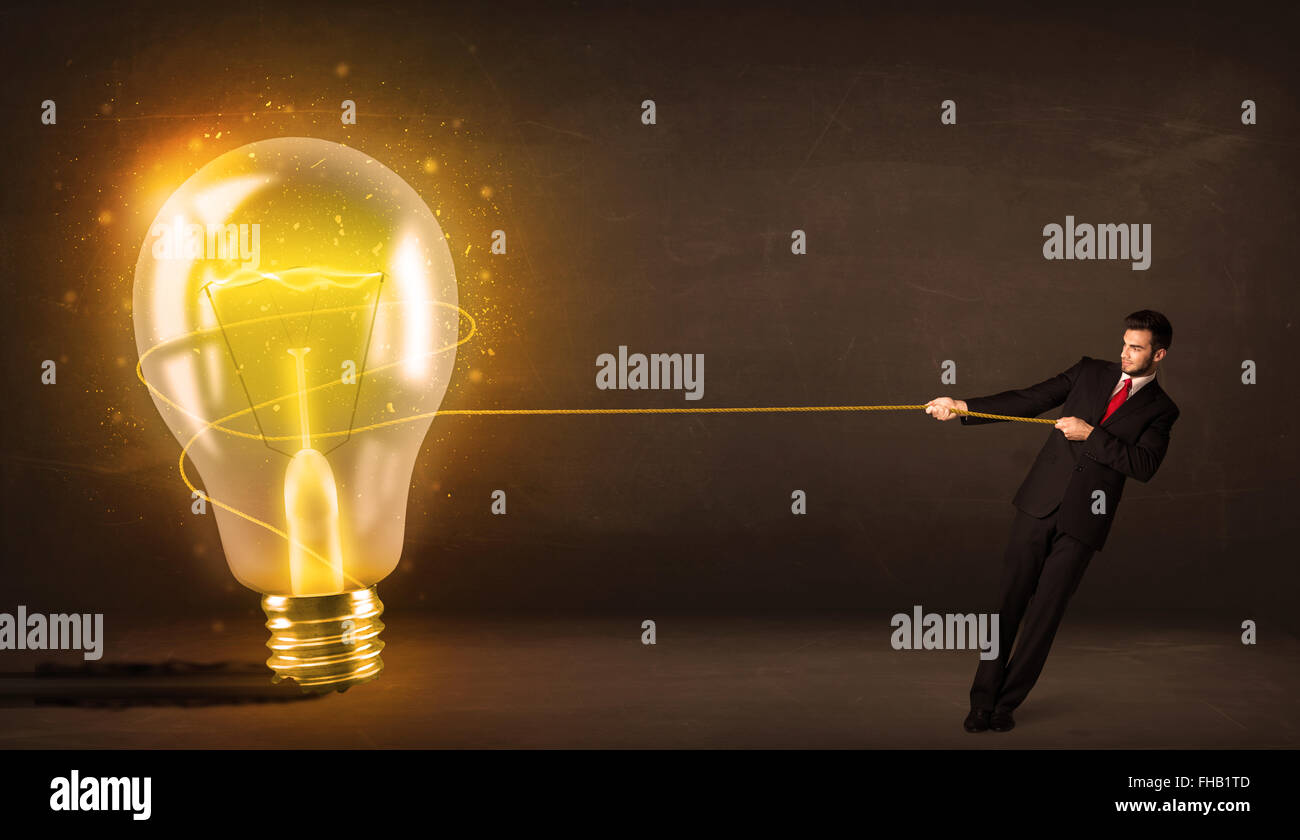 Business man tirando una grande e luminosa incandescente lampadina della luce Foto Stock