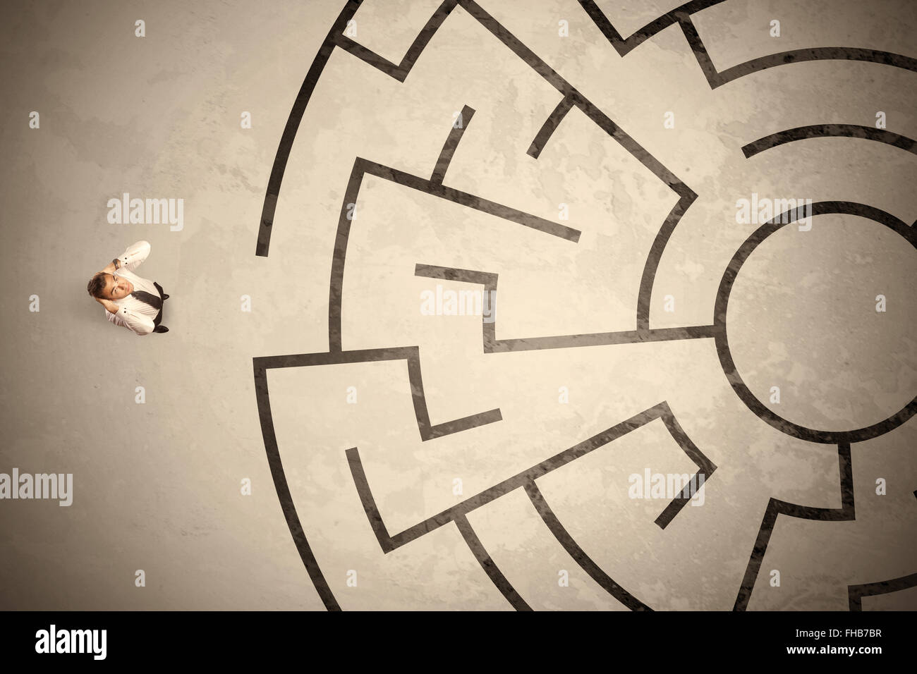 Perso il business man cercando un modo nel labirinto circolare Foto Stock
