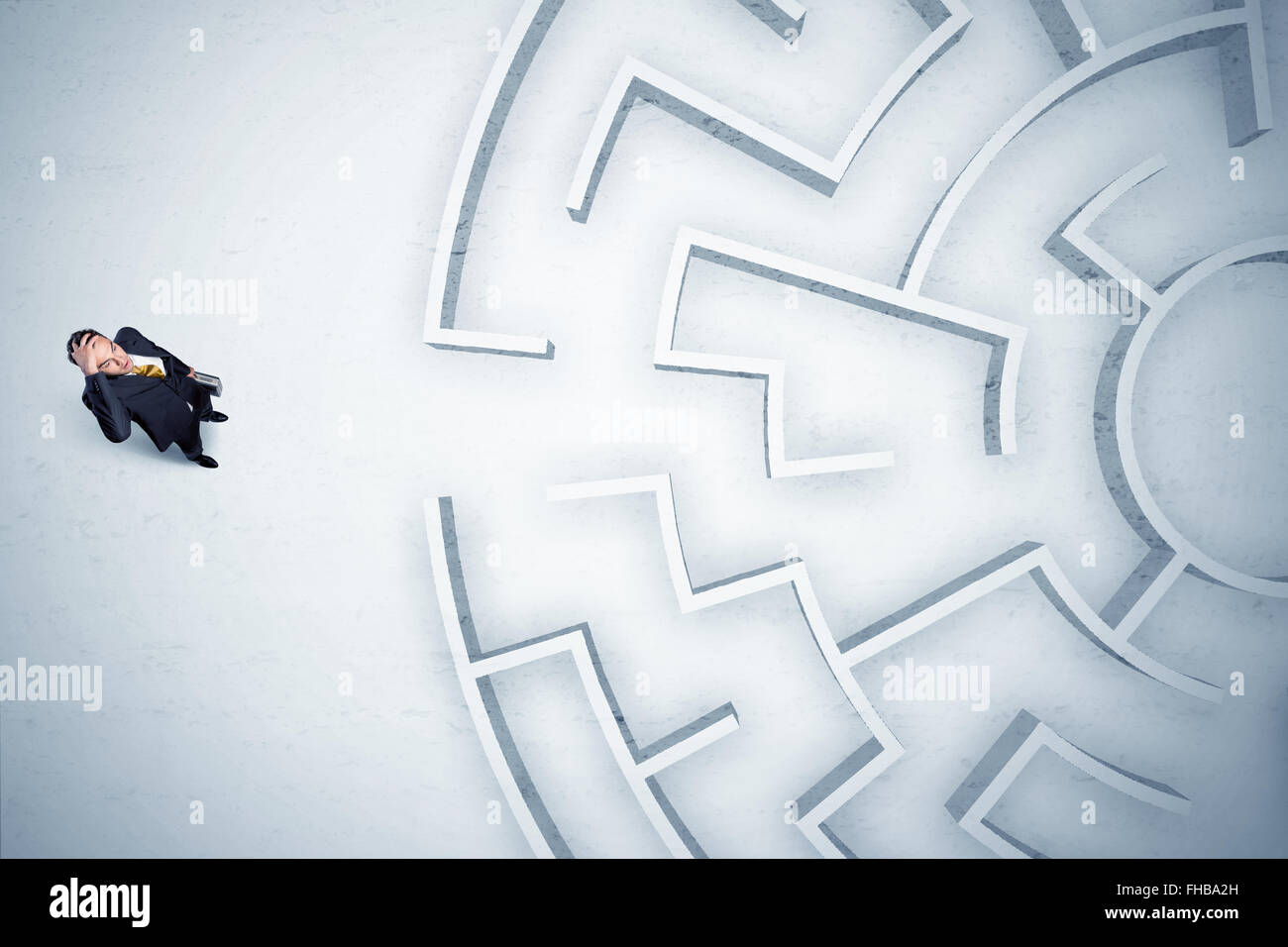 Uomo d'affari alla ricerca a labirinto circolare con nessun posto dove andare Foto Stock